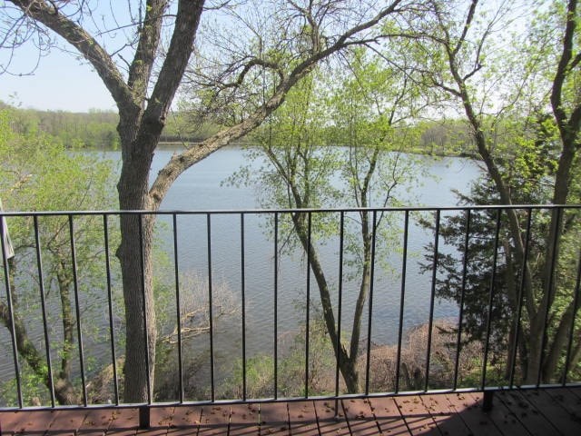 a balcony with a view of a lake and trees