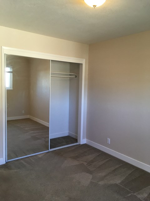 a bedroom with a closet and a floor to ceiling mirror