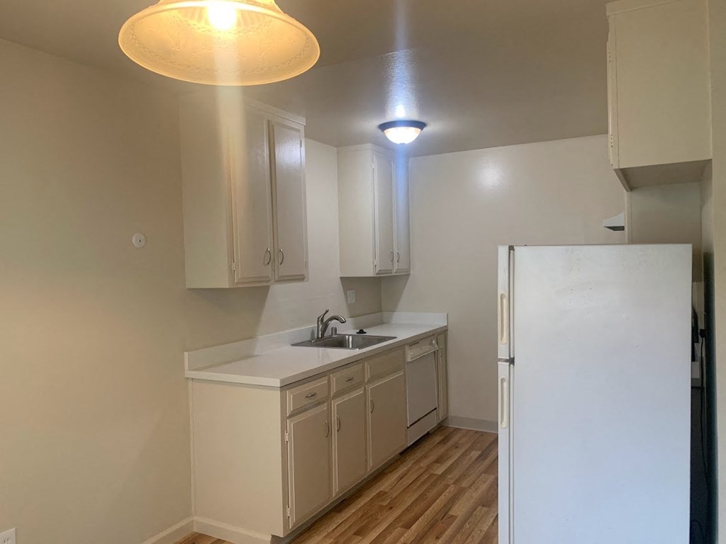 a kitchen with white cabinets and a refrigerator