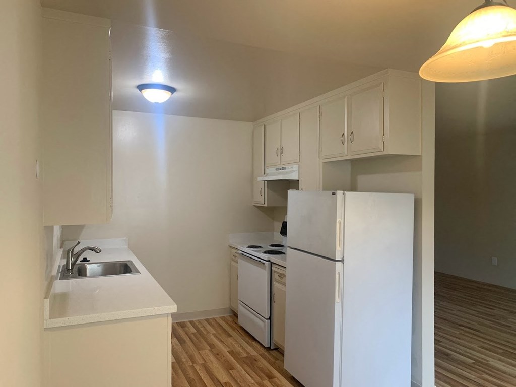 a kitchen with white cabinets and a white refrigerator