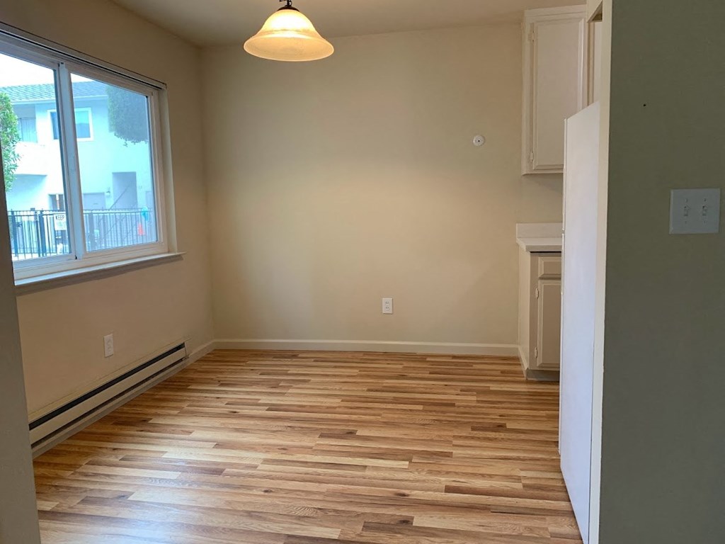 a empty living room with wooden floors and a window