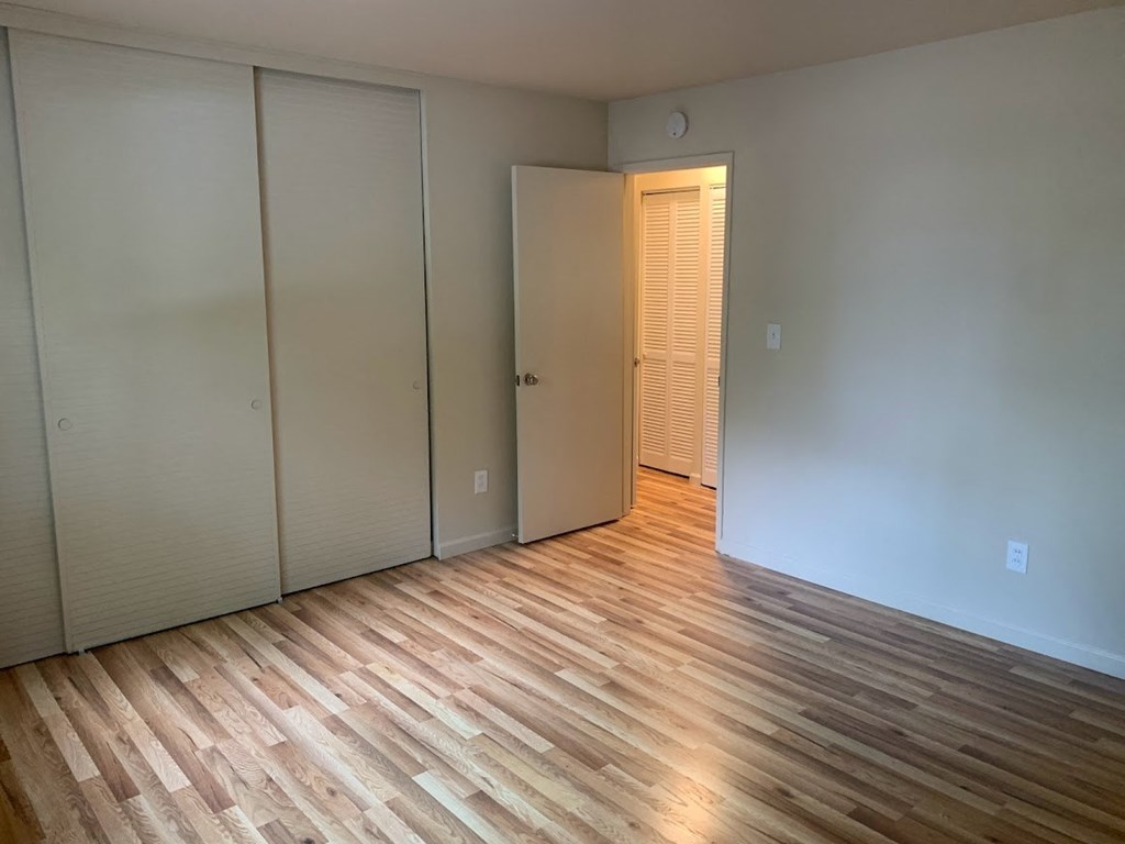 a living room with a wood floor and a door to a closet