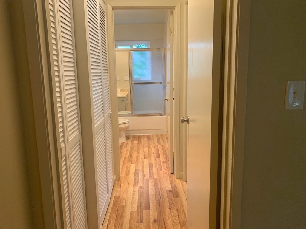a hallway with a door open to a bathroom