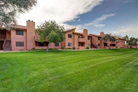 A large house with a green lawn in front.