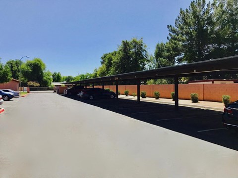 A parking lot with cars parked and trees in the background.