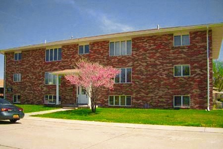 a red brick building with a pink tree in front of it