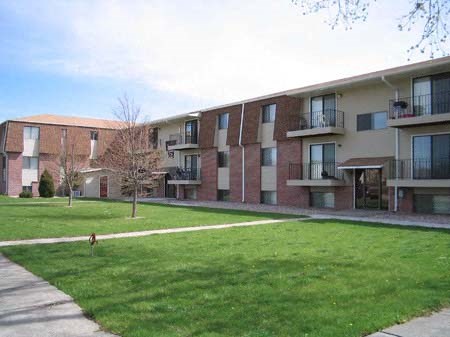 an apartment building with a dog walking in the grass