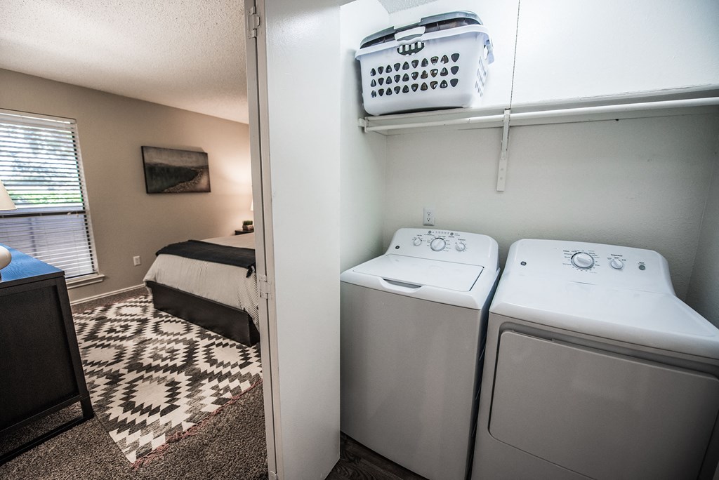 an empty laundry room with two washers and a dryer