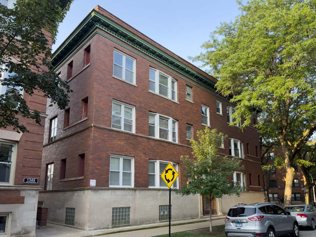 a red brick building with cars parked in front of it