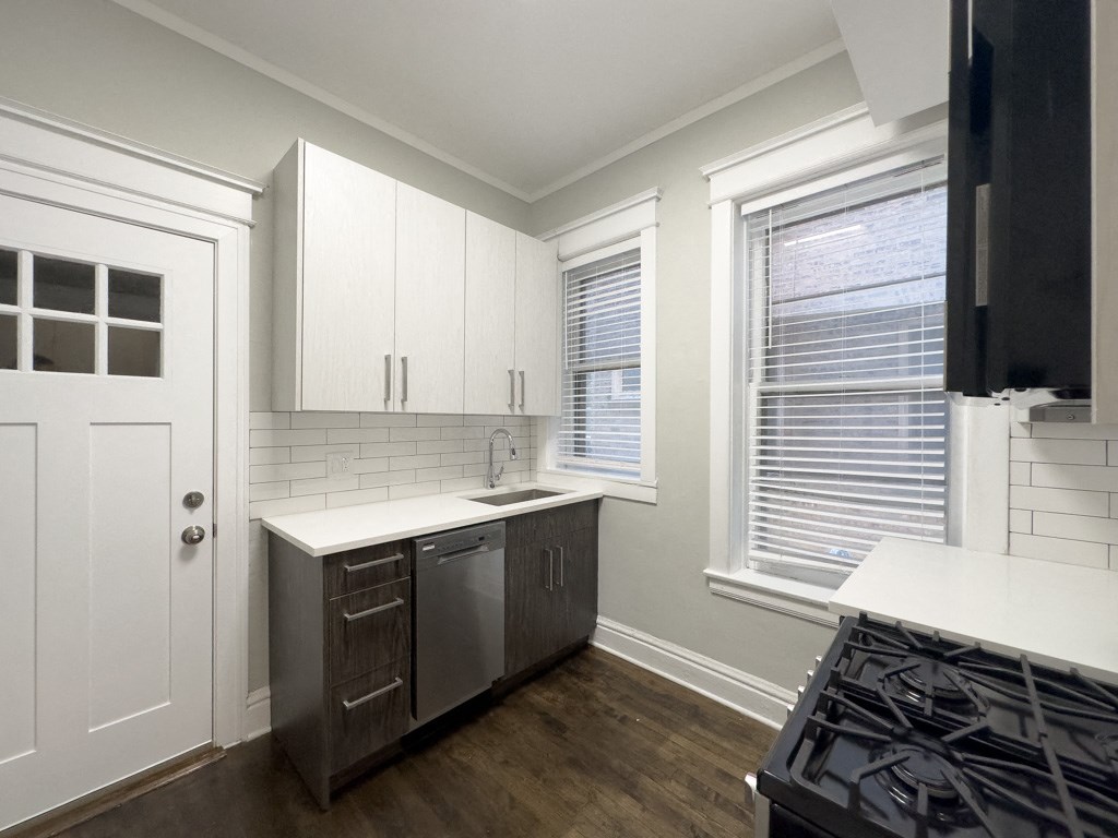 an empty kitchen with a stove and a window