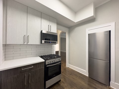a kitchen with stainless steel appliances and white cabinets