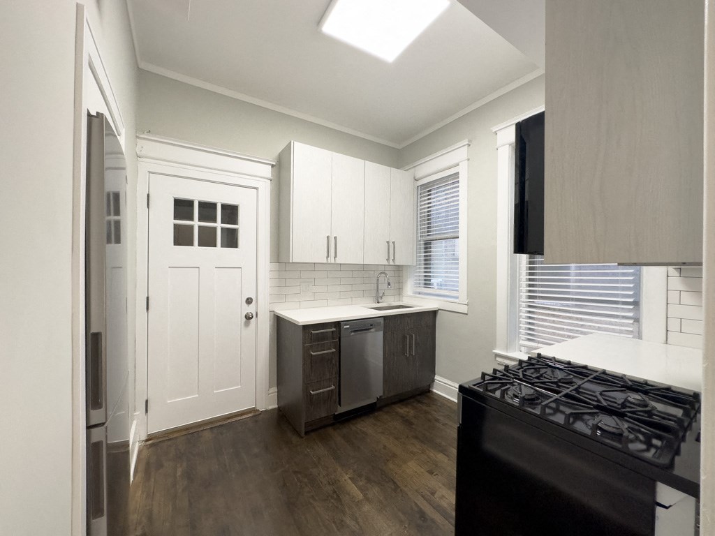 a kitchen with white cabinets and a stove and a refrigerator