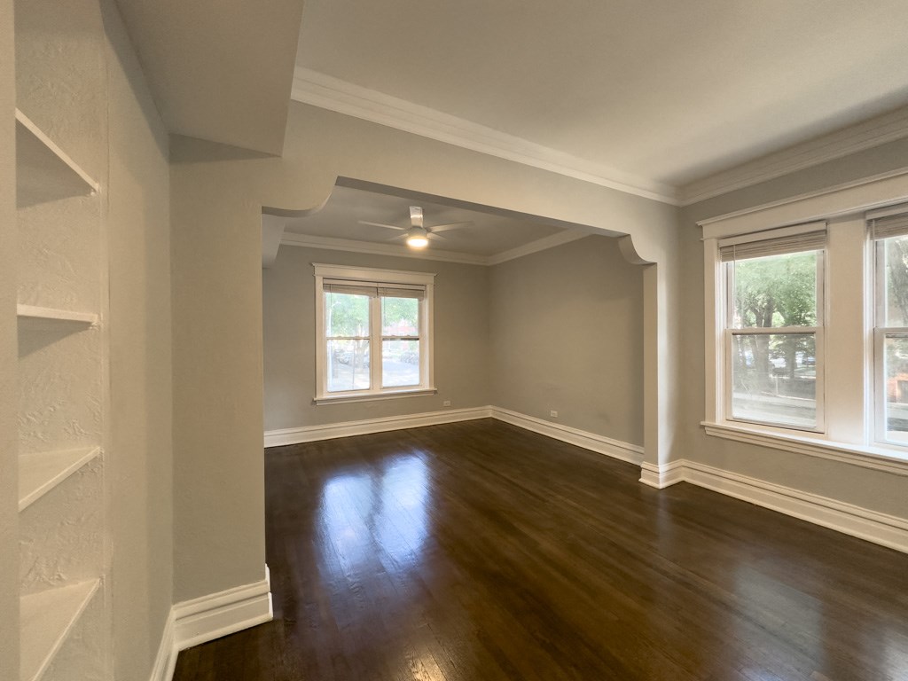 an empty living room with a hard wood floor and windows