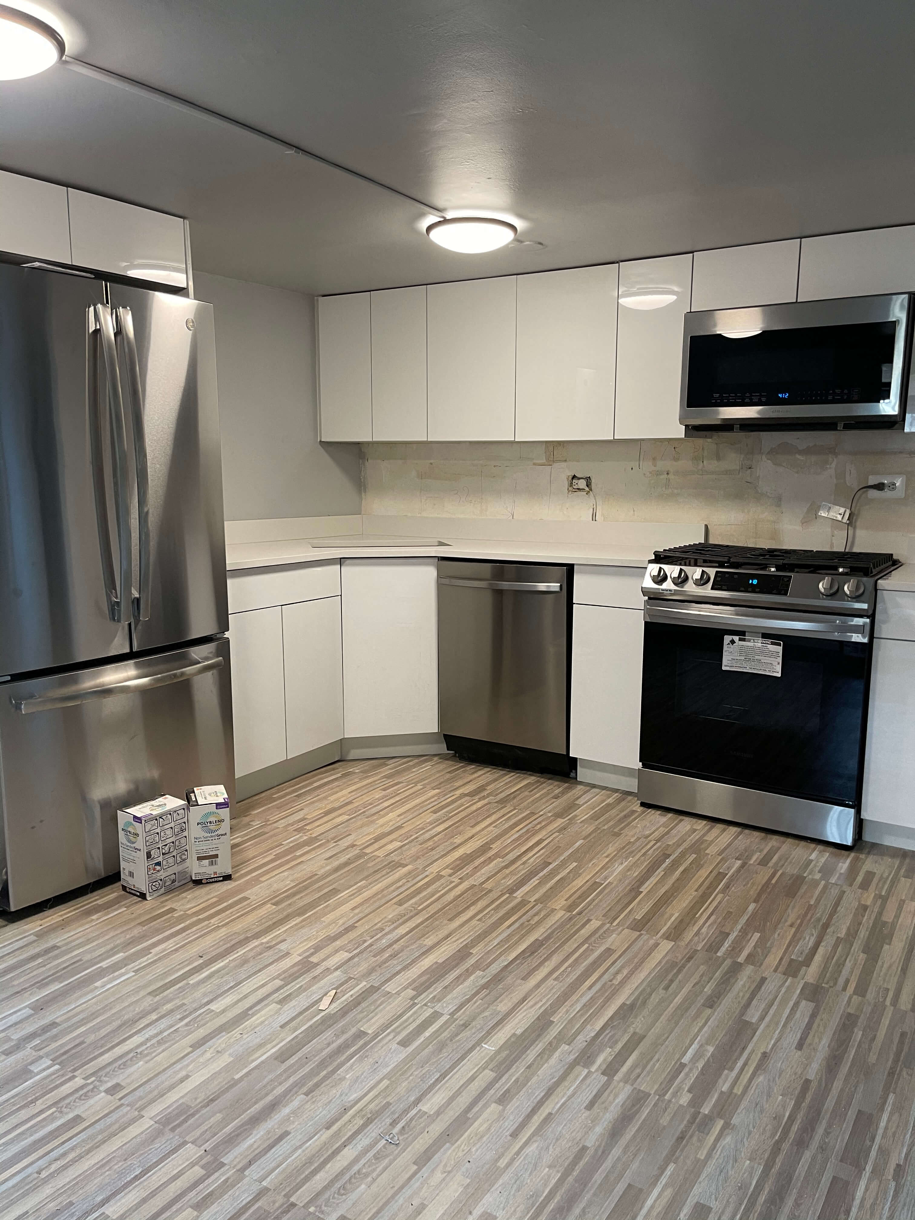 a kitchen with stainless steel appliances and a wooden floor