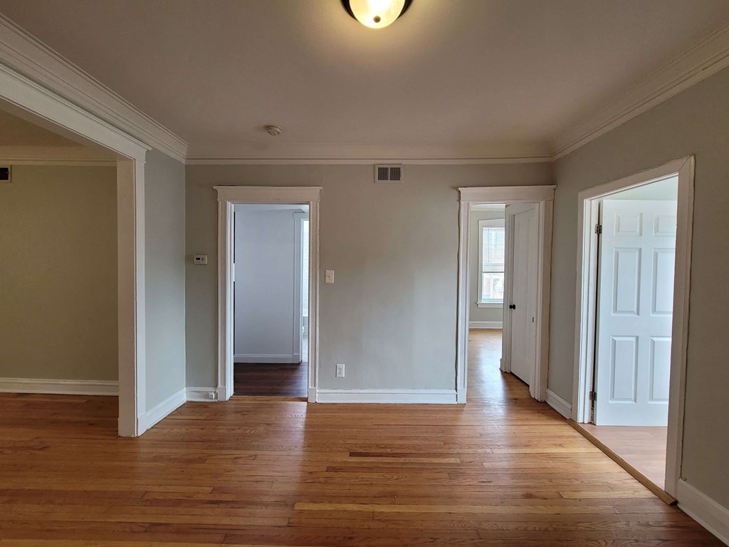 a living room with a hard wood floor and several doors
