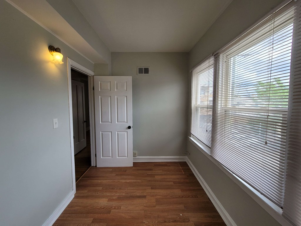 an empty room with a large window and a door
