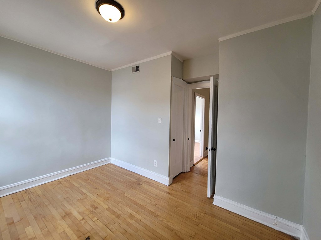 a empty living room with a wooden floor and white walls