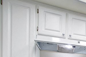 a kitchen with white cabinets and a white stove top oven