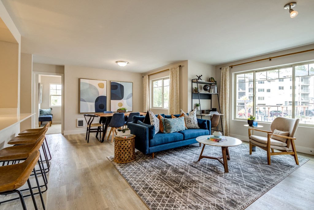a living room with a blue couch and a dining room table