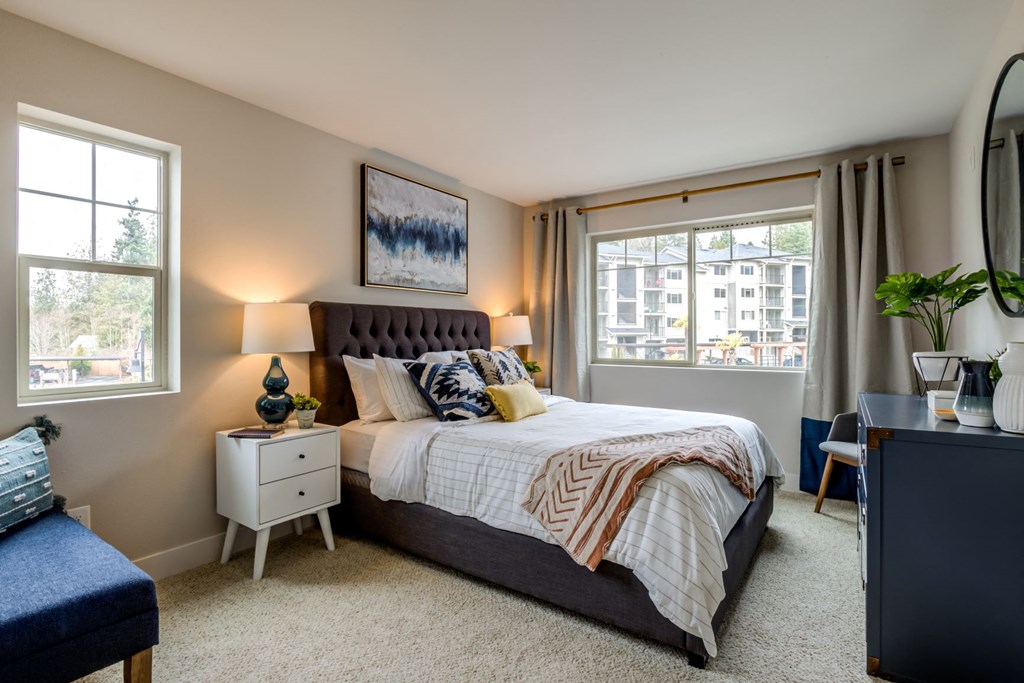 a bedroom with a bed and two windows