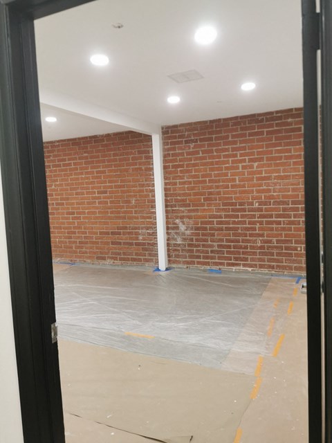 A room with a brick wall and a white pipe.