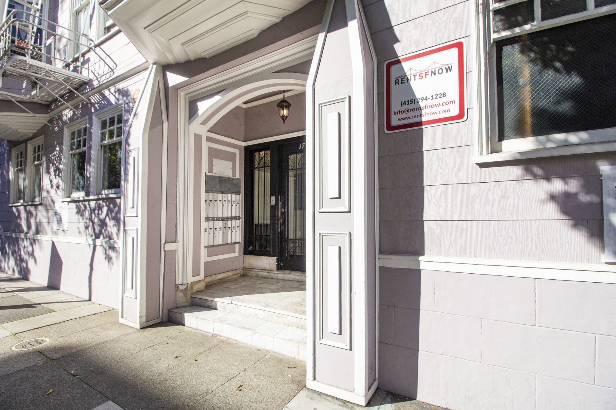 A white building with a black door and a sign that says "RETAIN".