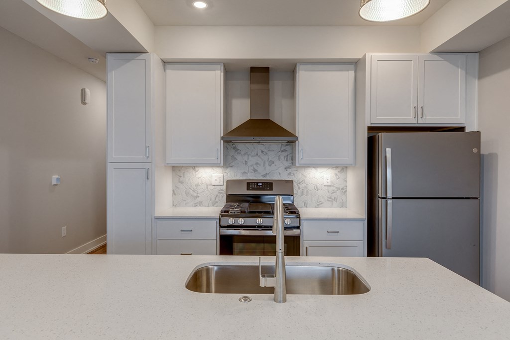 a kitchen with white cabinets and stainless steel appliances