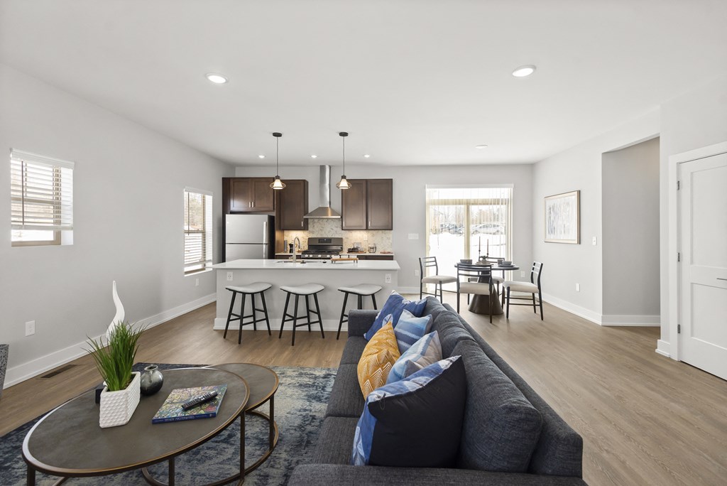 a living room with a couch and a kitchen with a table and chairs