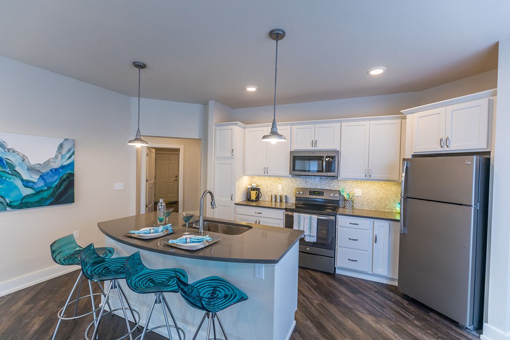 a kitchen with stainless steel appliances and a bar with stools