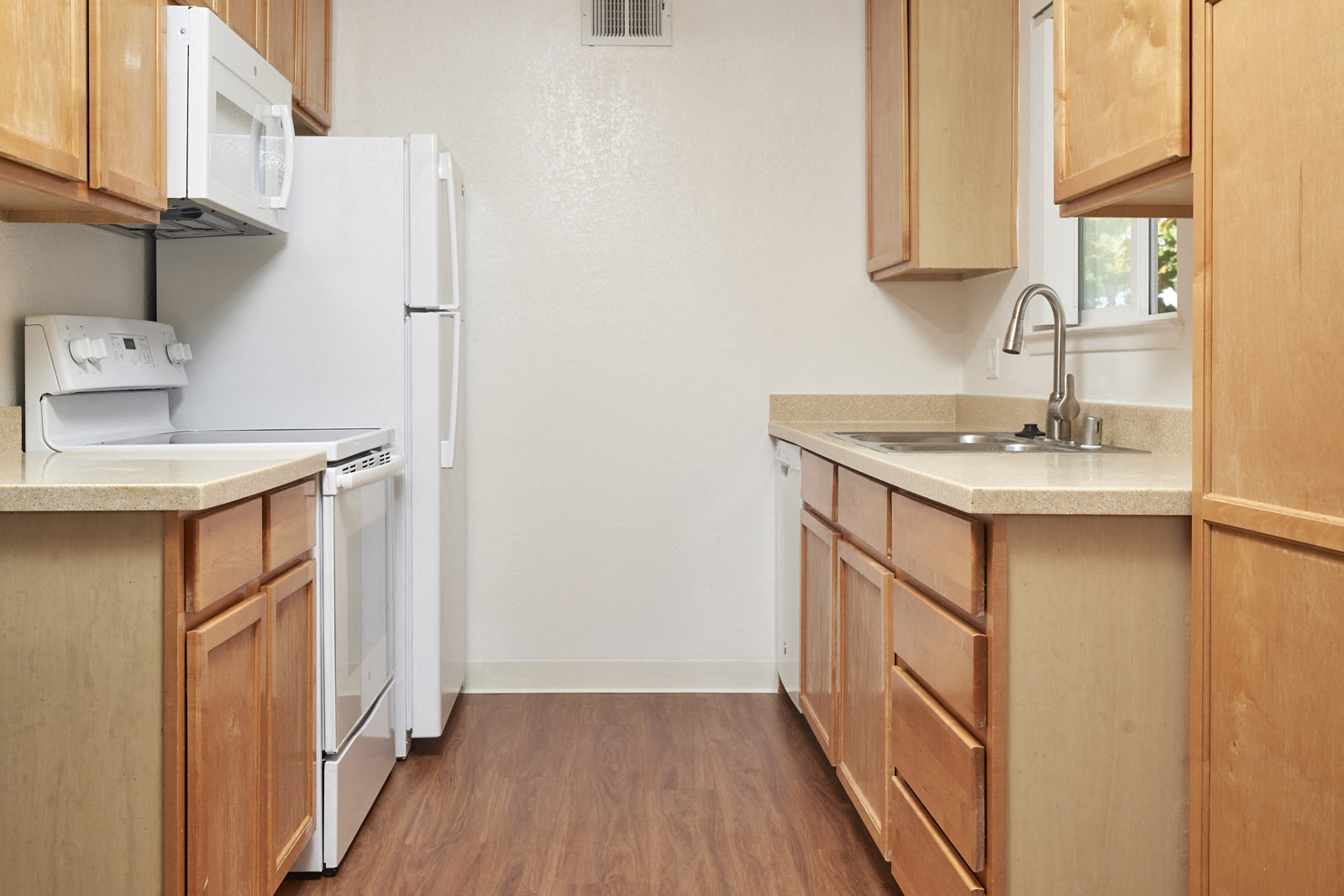 A kitchen with wooden cabinets and a white refrigerator.