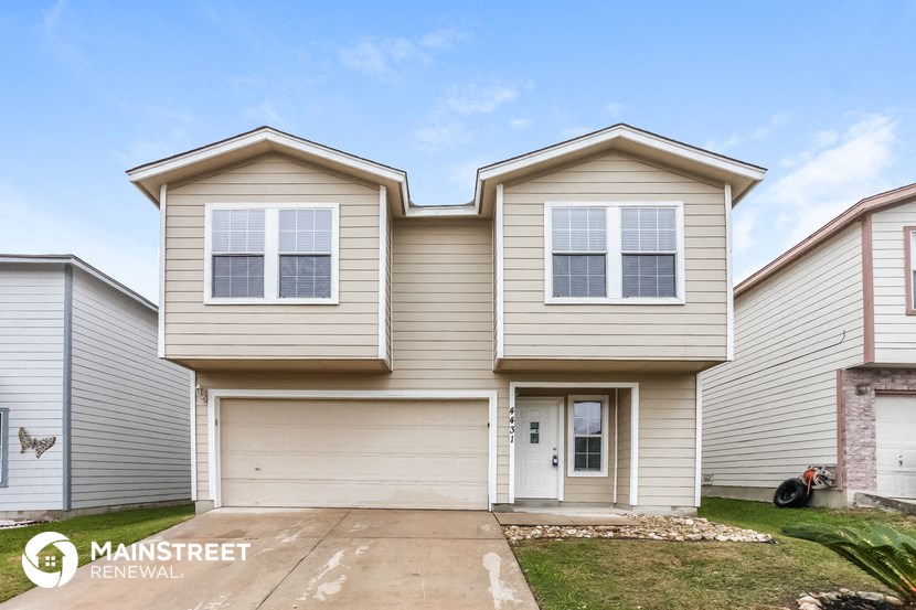 a beige house with two roofs on top of it