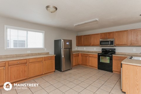 a kitchen with wooden cabinets and a stainless steel refrigerator