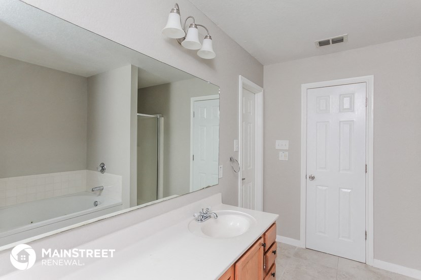 a bathroom with a large mirror and a sink and a tub