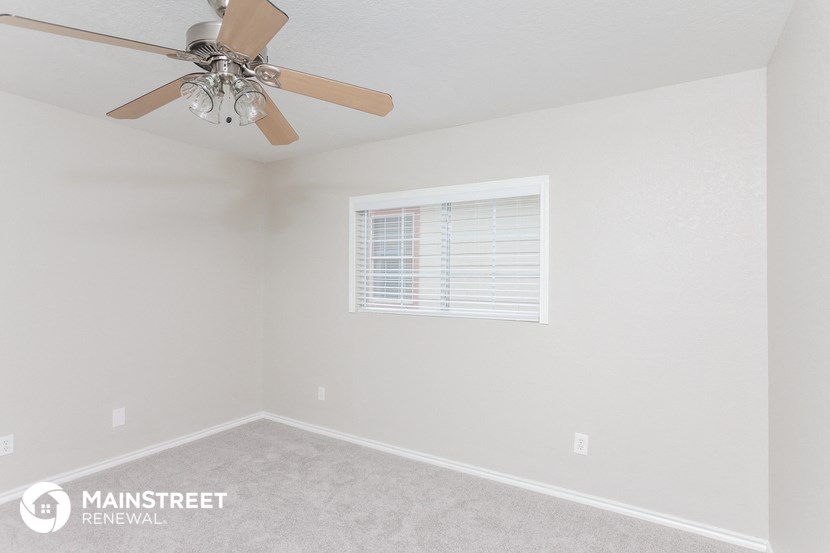 a bedroom with a ceiling fan and a window