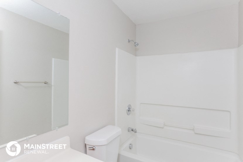 a white bathroom with a toilet and a tub and a sink