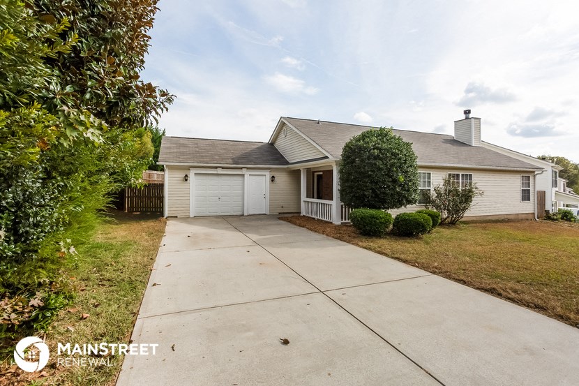 a small white house with a sidewalk in front of it