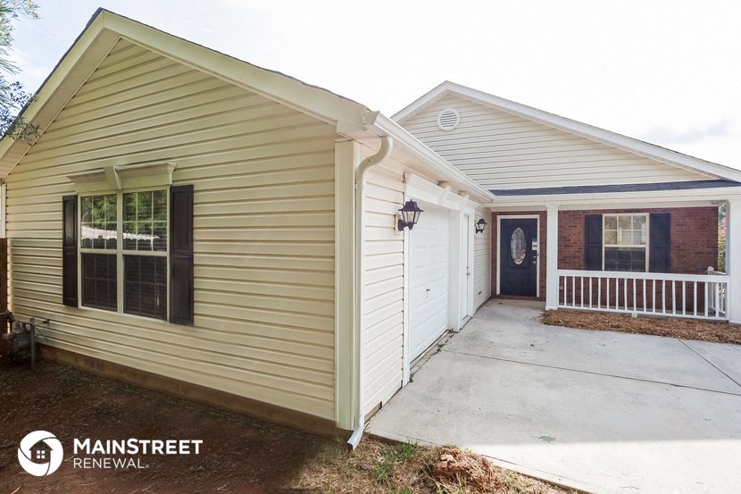 the front exterior of a home with a porch and a driveway