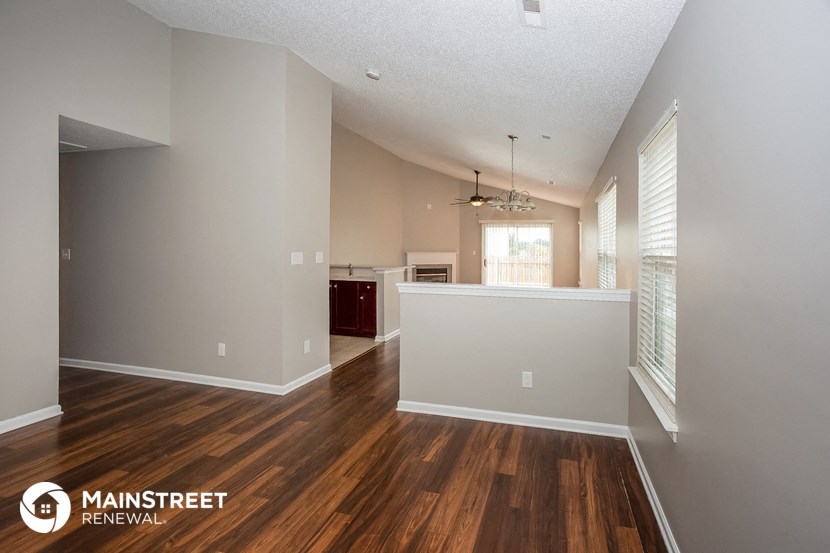 the spacious living room and kitchen with hardwood flooring