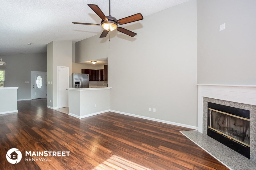 a living room with a fireplace and a ceiling fan