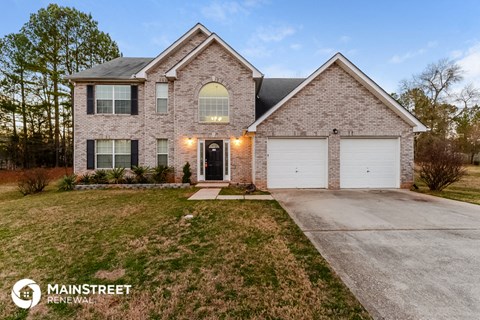 a brick house with a white garage door and a lawn