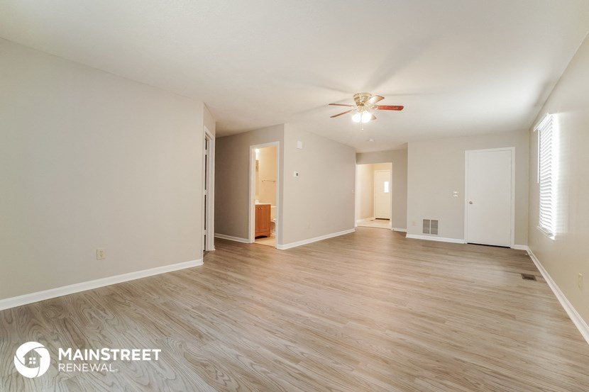 the living room and dining room with wood flooring and a ceiling fan