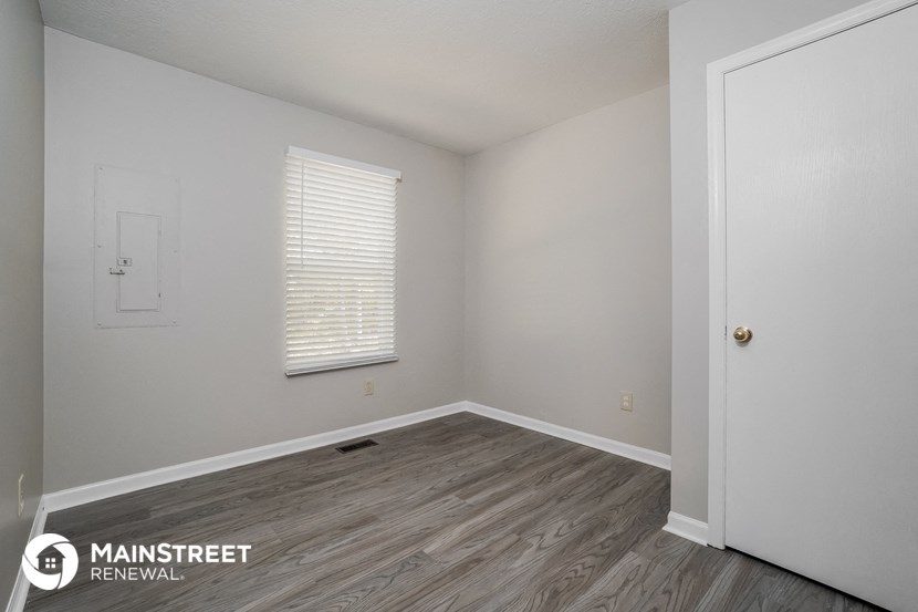 the interior of a white room with wood flooring and a white door