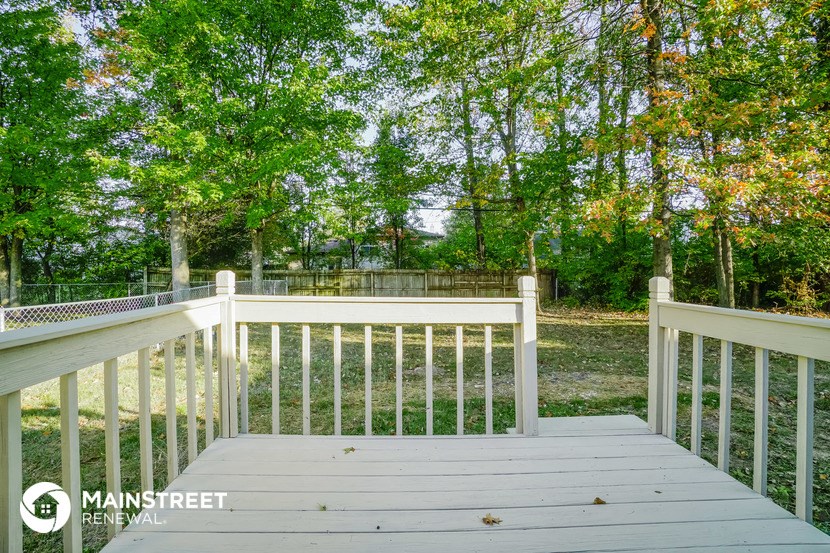 a deck with a view of a yard and trees