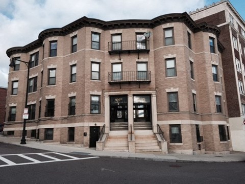 A large brick building with a black door and windows.