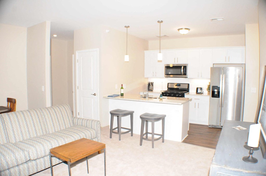 a living room with a couch and a kitchen