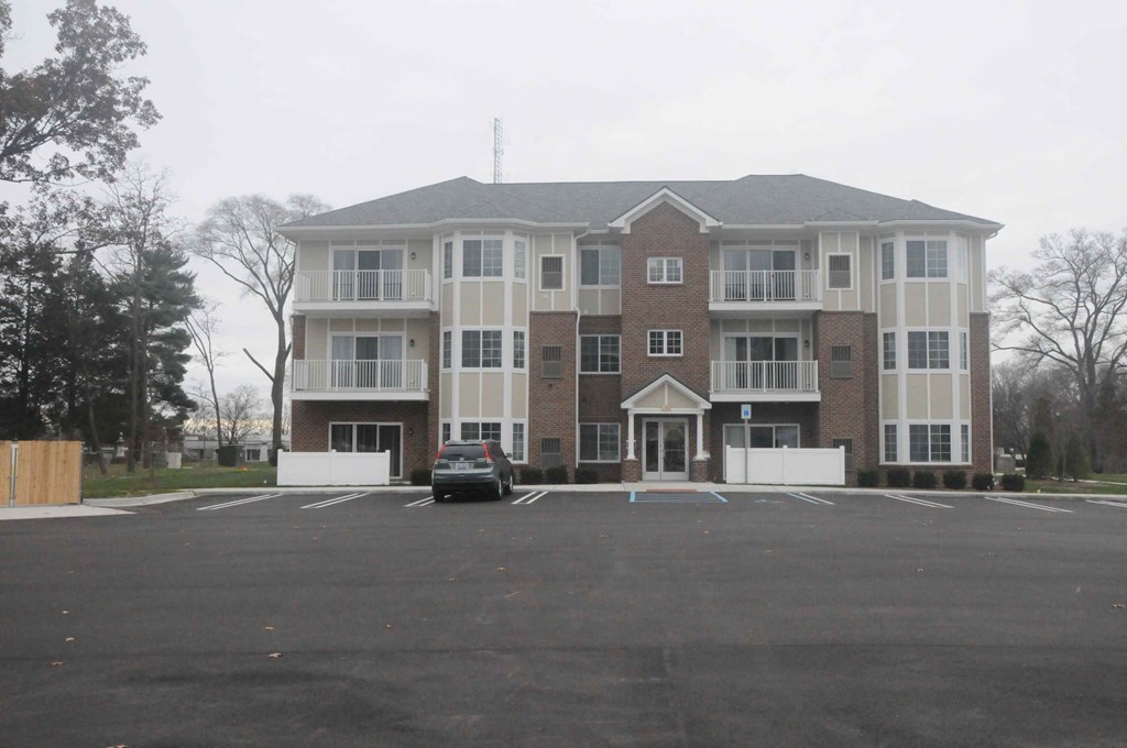 an empty parking lot in front of a large apartment building