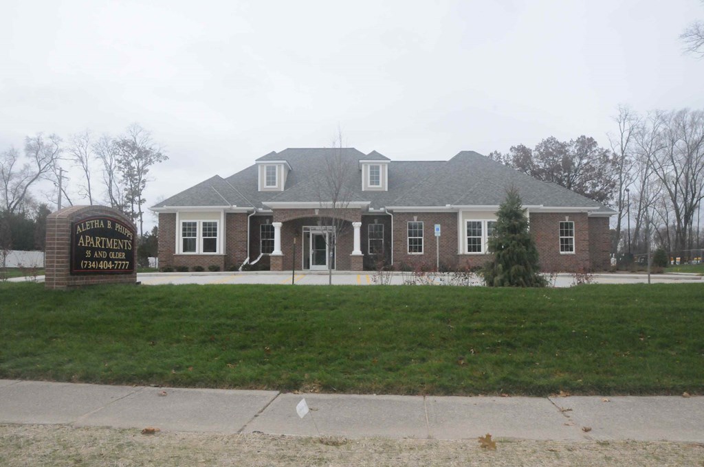 a view of the front of a brick house with a sidewalk and grass