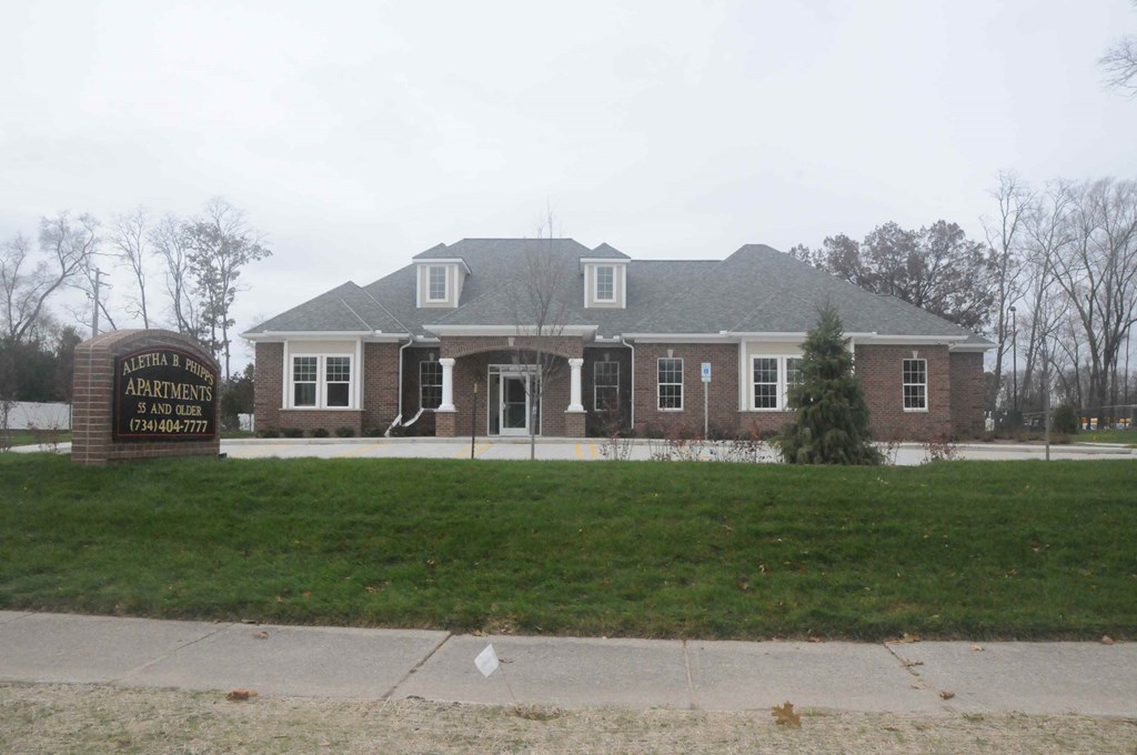 a view of the front of a brick house with a sign in front
