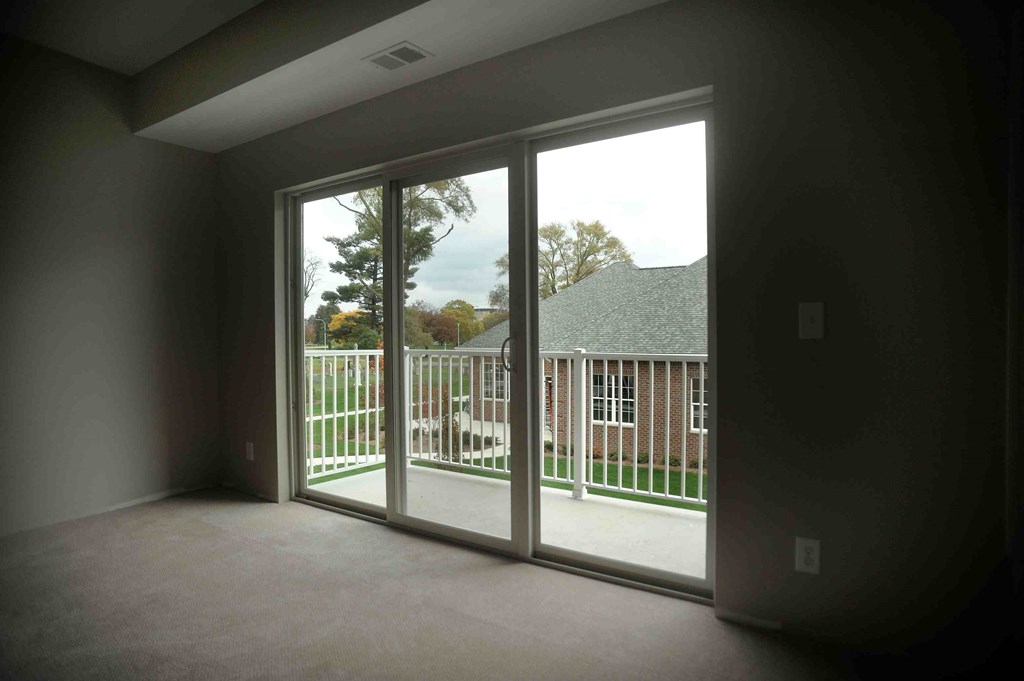 an empty living room with sliding glass doors to a balcony