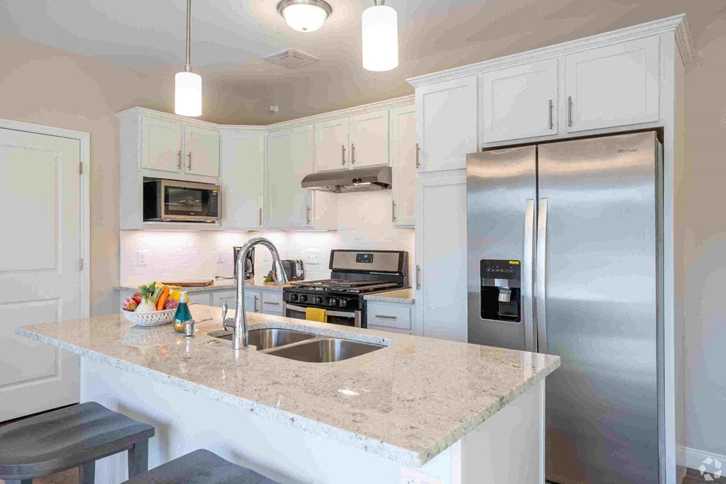 a white kitchen with stainless steel appliances and a counter top